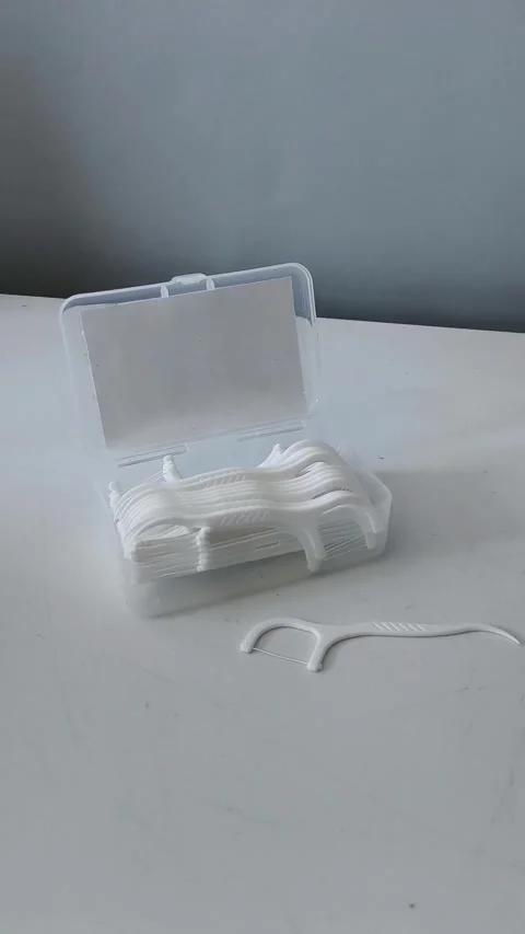 Close-up of a container of dental floss and flossers on a table. Teeth cleaning Vidéo 329969471
