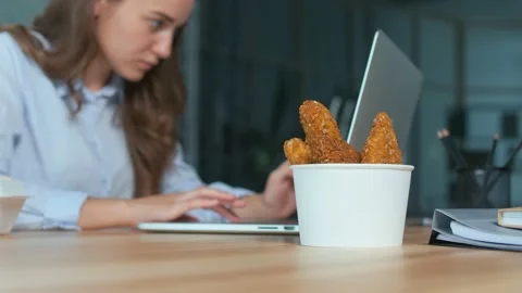 Close-up. Container with Nuggets on the Background of a Working Young Woman Stock Footage 170061732