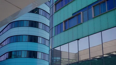 Close-up of contrasting modern building facades with curved blue and patterned Stock Footage 338323271