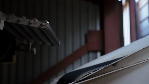 Close-up conveyor rollers rotate, wheat bag falls on conveyor belt 库存影片 98102260