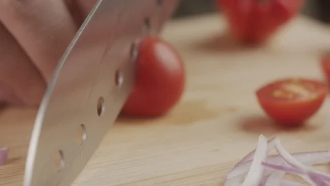 Close-up of cook cuts beautiful cherry tomatoes with sharp knife on wooden board Stock Footage 123099231