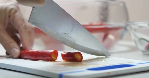 Close-up Cook Cuts Fresh Hot Red Chili Peppers With A Knife On A Cutting Board Stock Footage 128096335
