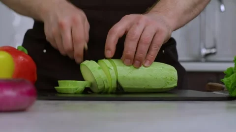 Close-up. The cook cuts the zucchini with a kitchen knife. The camera moves Stock Footage 269120125