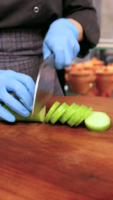 Close-up of Cook Cutting Cucumber with Kitchen Knife Stock Footage 288577914