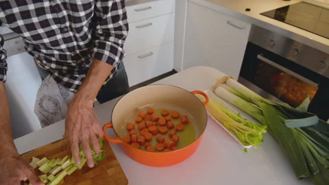 Close up of cook hands adding fresh vegetables to iron pan. 库存影片 131538860