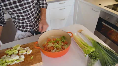 Close up of cook hands adding fresh vegetables to iron pan 库存影片 131541369