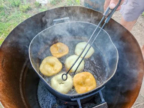 Close up of cook hands flipping Argentinian frybreads to cook on both sides.. Stock Photos
