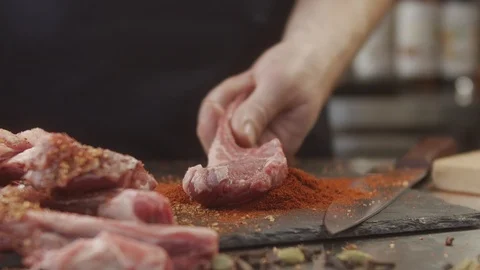 Close-up of cook in the kitchen preparing beef ribs with spices Stock Footage 123898905