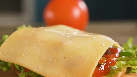 Close up: cook prepares a hamburger: a tomato falls on a chop, cheese and onions Stock-Footage 111344976