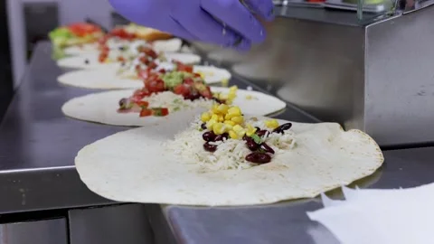 Close-Up of Cook Preparing Burrito with Rice, Beans, Corn, and Vegetables Stock Footage 288576825