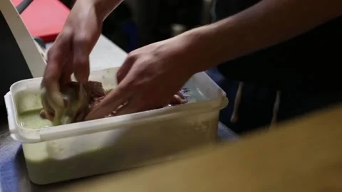 Close up of a cook preparing a lamb marinade with his hands Stock Footage 137945745
