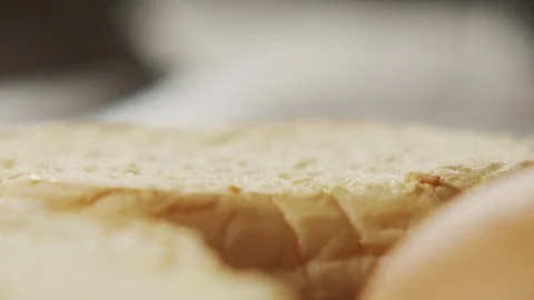 Close-up of a cook puts piece of butter on bun. Slow motion video Stock Footage 116244472