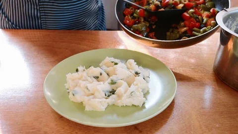 Close-up of cook serving mashed potatoes prepared with herbs in white plate. Stock Footage 100590148