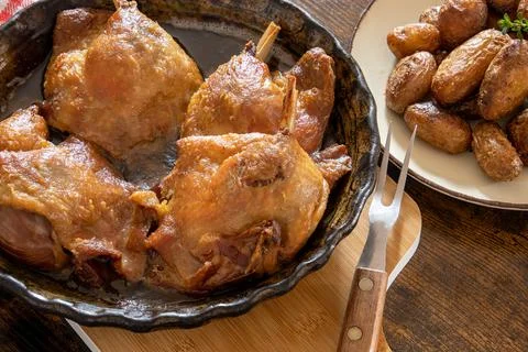 Close up of cooked duck confit in a dish with potatoes Stock Photos