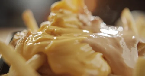 Close-up on cooked fries add cheese sauce and mayonnaise. 4K Slow Motion Stock Footage 116247041