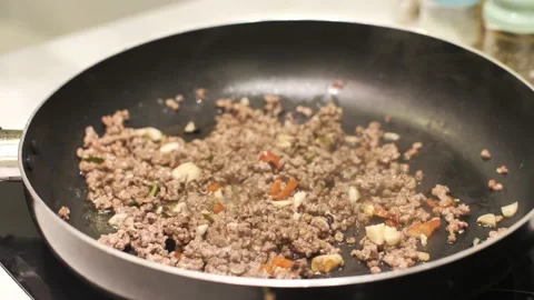 Close up on cooked ground meat in the pan with a hand pouring soy sauce in it. Stock Footage 154228433