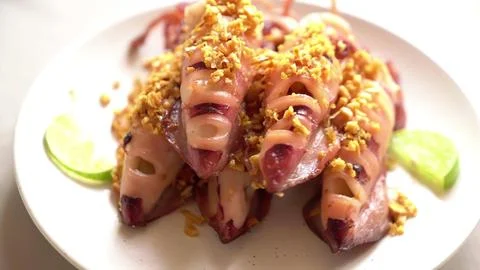 Close-up of cooked pork with crunchy nuts on a white plate Stock Photos
