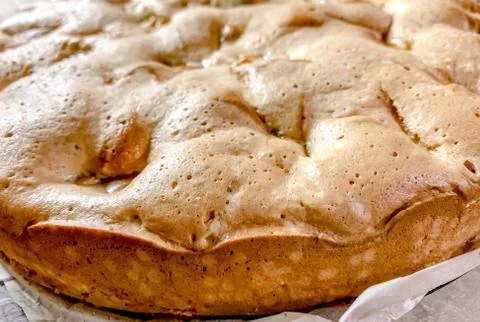 The close up of the cooked sponge cake with apples, top view. Food textures. Stock Photos