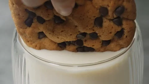 Close-Up of Cookie Being Dipped into Glass of Milk Stock Footage 318087928