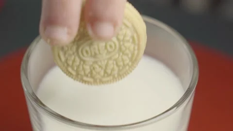 Close up of a cookie being dunked in a glass of milk Stock Footage 150812623