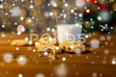 Close up of cookies and milk over christmas lights Stock Photos