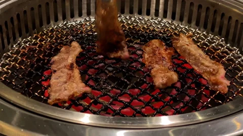 Close up of cooking a bbq and flip the meat in 4k footage Stock Footage 257874349