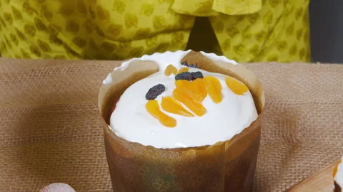 Close-up cooking delicious Easter cakes. Female hands decorating with pieces of Stock Footage 172158385