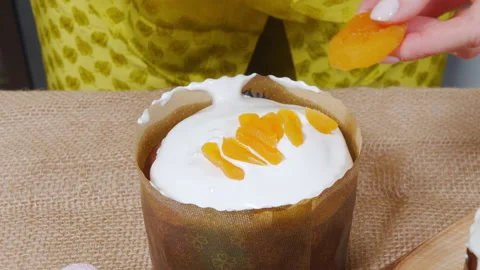 Close-up cooking delicious Easter cakes. Female hands decorating with pieces of Stock Footage 172258331