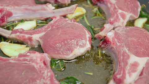 Close-up cooking lamb ribs, cutlets into a frying pan with greens in 4K. Stock Footage 145999194