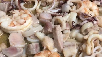 Close up of cooking a mix of prawns, squids and other fish in olive oil. Stock-Footage 86131105