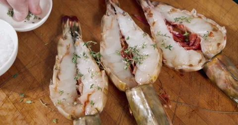 Close-up of cooking process of large shrimps with spices, salt, herbs and garlic Stock Footage 152582490
