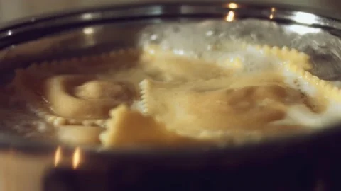 Close-up of cooking ravioli by placing them in a pan with boiling water Stock Footage 238997345
