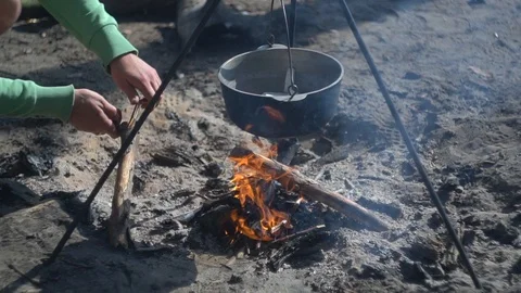 Close-up. cooking at the stake. hands tossing brushwood into the fire. Stock-Footage 113279301