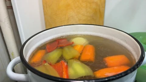 Close-Up of Cook's Hand Removing Lid from Pot of Vegetable Soup Stock Footage 329910918