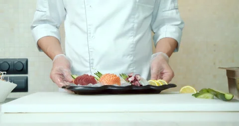 Close-up of cook's hands in gloves serving a dish of fresh fish and vegetables Stock Footage 133666549