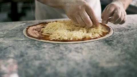 Close up for cook's hands putting cheese on the pizza Four Cheeses.Chef adding Stock Footage 197786359