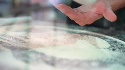 Close-up of the cook's hands. Rolls out and stretches pizza dough. Video stock 231336566