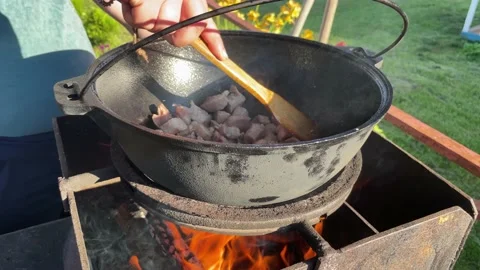 Close-up of the cook's hands stirring meat with a spatula in a cauldron Stock Footage 200843017