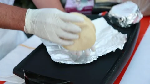 Close up of cook's hands wrapping Mexican tortillas on aluminum foil Stock Footage 67365966