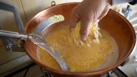 Close-up of copper cauldron with boiling water and pouring yellow cornmeal 스톡 동영상 126400641