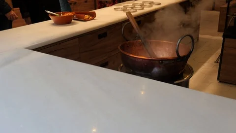 Close up on a copper cauldron with nougat cooking with fumes and a wood spoon. Stock Footage 122290475