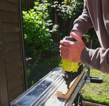 Close-up of cordless battery powered nail gun securing siding panel Stock Photos
