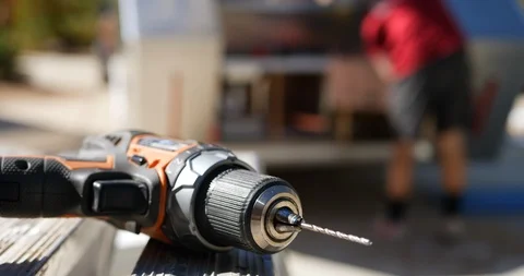 Close up of a cordless drill with a drill bit in the sun as a construction Video stock 97773125