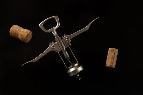 Close-up corkscrew and wine corks on the black background.	 Stock Photos