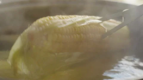 Close-up of corn pricked on a fork boiling in a saucepan to check for readiness 库存影片 337118663