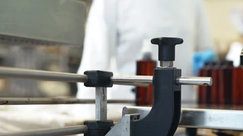 Close-up of the corner of a conveyor belt where a factory worker places bottles 動画素材 311998638