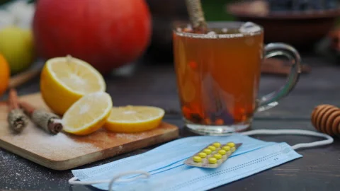 Close-up coronavirus face mask and pills blister with green tea pouring in cup Stock Footage 237516585