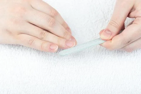 Close-up corrects the shape of the nails with a nail file. Stock Photos