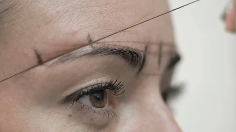 Close-Up Cosmetician Draws Lines Threads Around Client Eyebrows Stock Footage 96998008