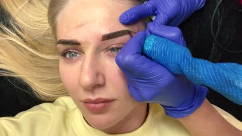 Close up of cosmetologist making permanent makeup. Microblading procedure Vídeo Stock 164918965